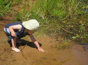 toddler playing in mud